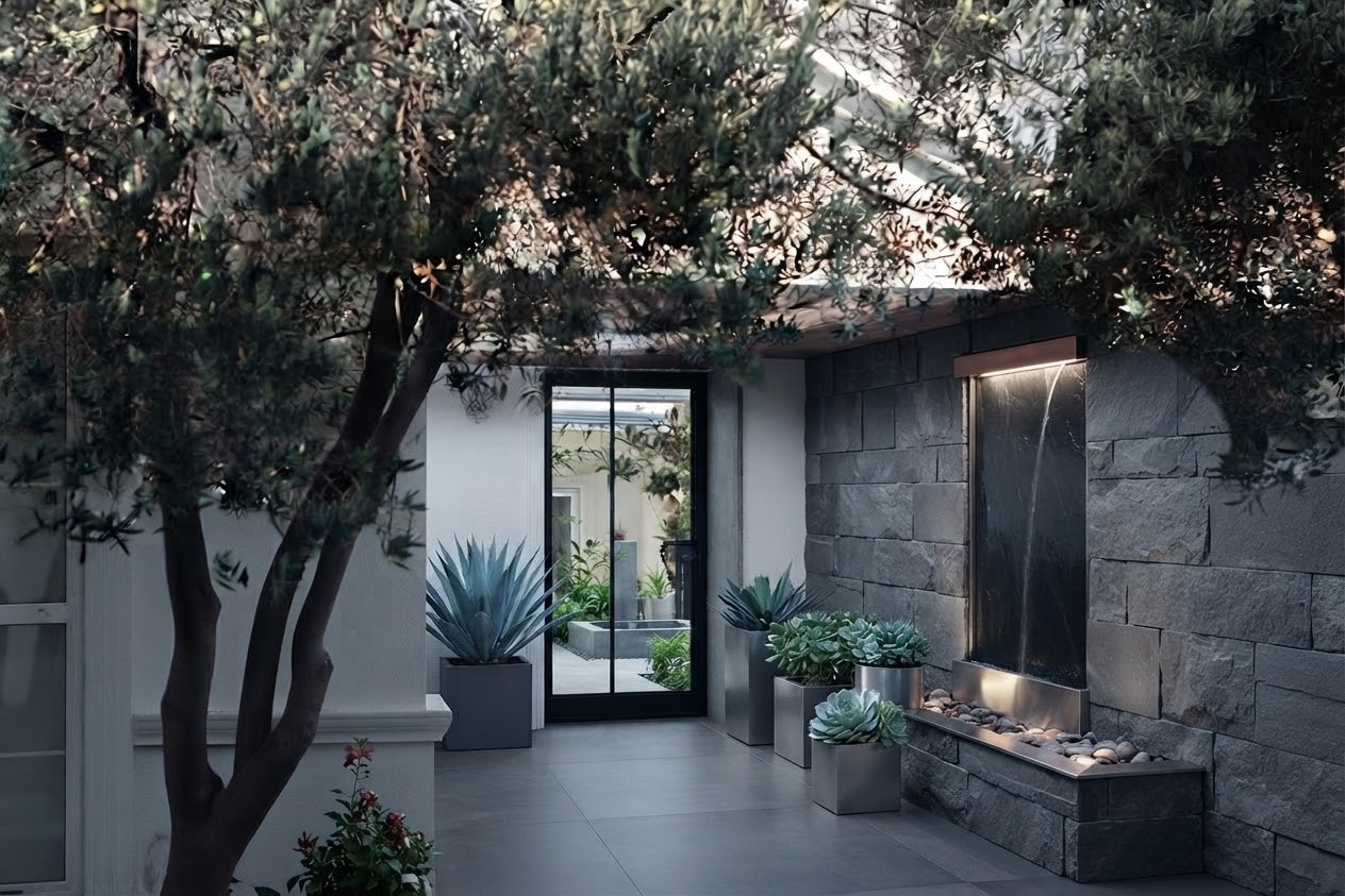 Courtyard garden with stone wall water feature and succulents